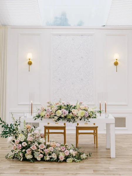 Conradie Event Design sweetheart table with pink and white florals in a white paneled room