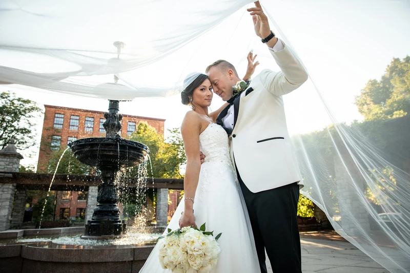 Jeffrey Foote Photography couple under a sweeping veil beside a courtyard fountain
