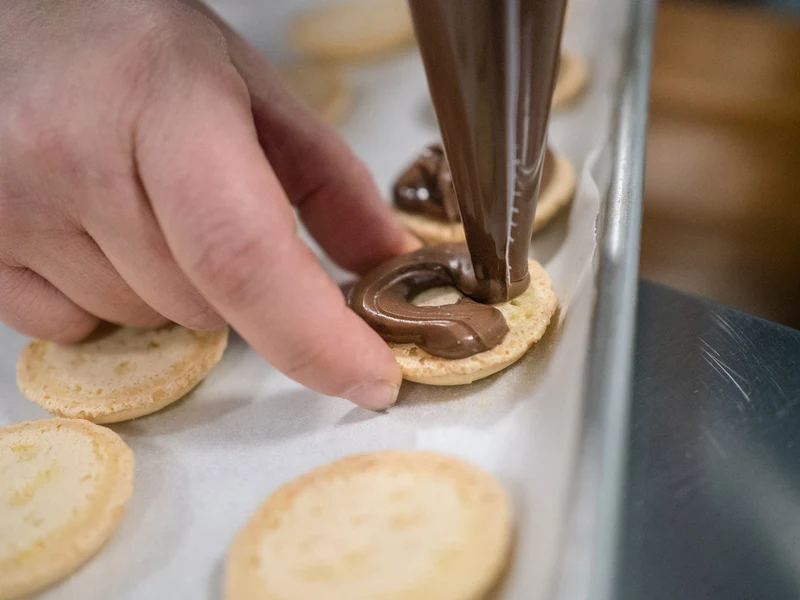 Ba-Li Cravings macarons being filled by hand in the kitchen