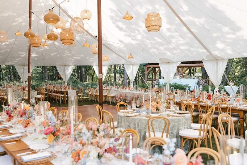 Fox & Fern Events tented wedding reception with paper lanterns and flower-lined tables at the edge of the woods