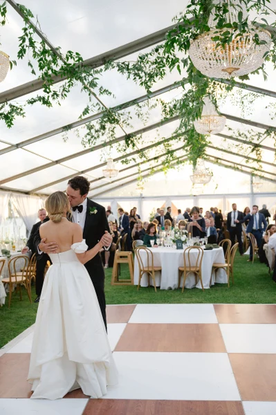 Fox & Fern Events first dance under a clear-top tent with chandeliers and hanging greenery