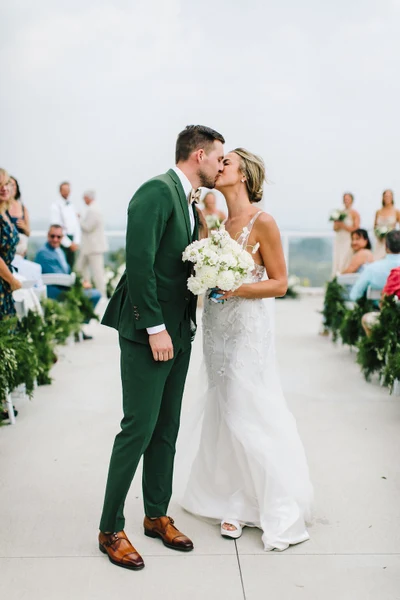 Fox & Fern Events couple kissing in the aisle at an outdoor ceremony