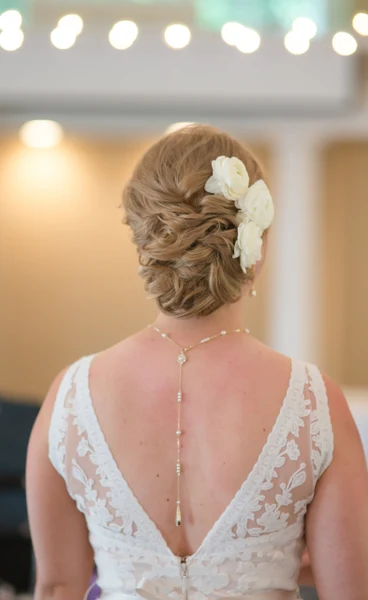On-Site Bridal bridal updo dressed with white flowers, seen from behind