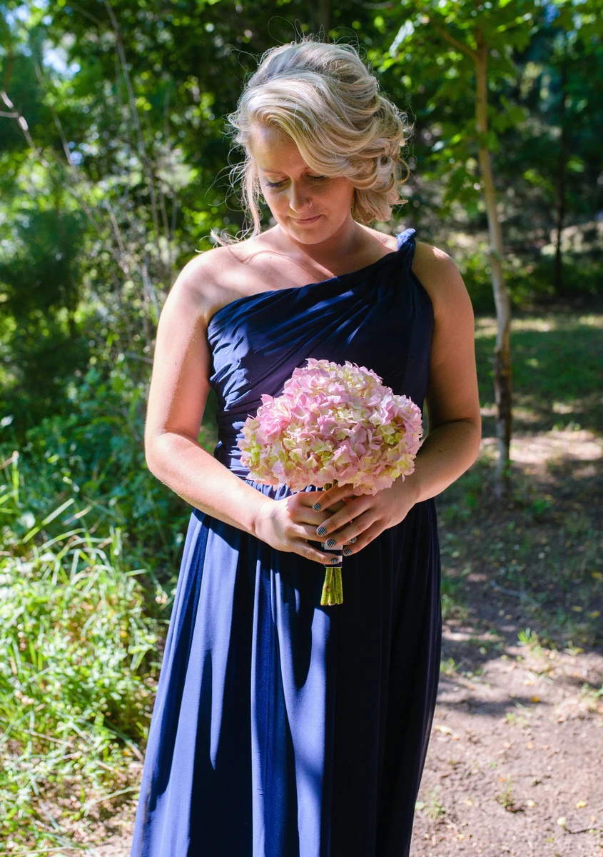 On-Site Bridal bridesmaid with a textured updo holding a pink hydrangea bouquet